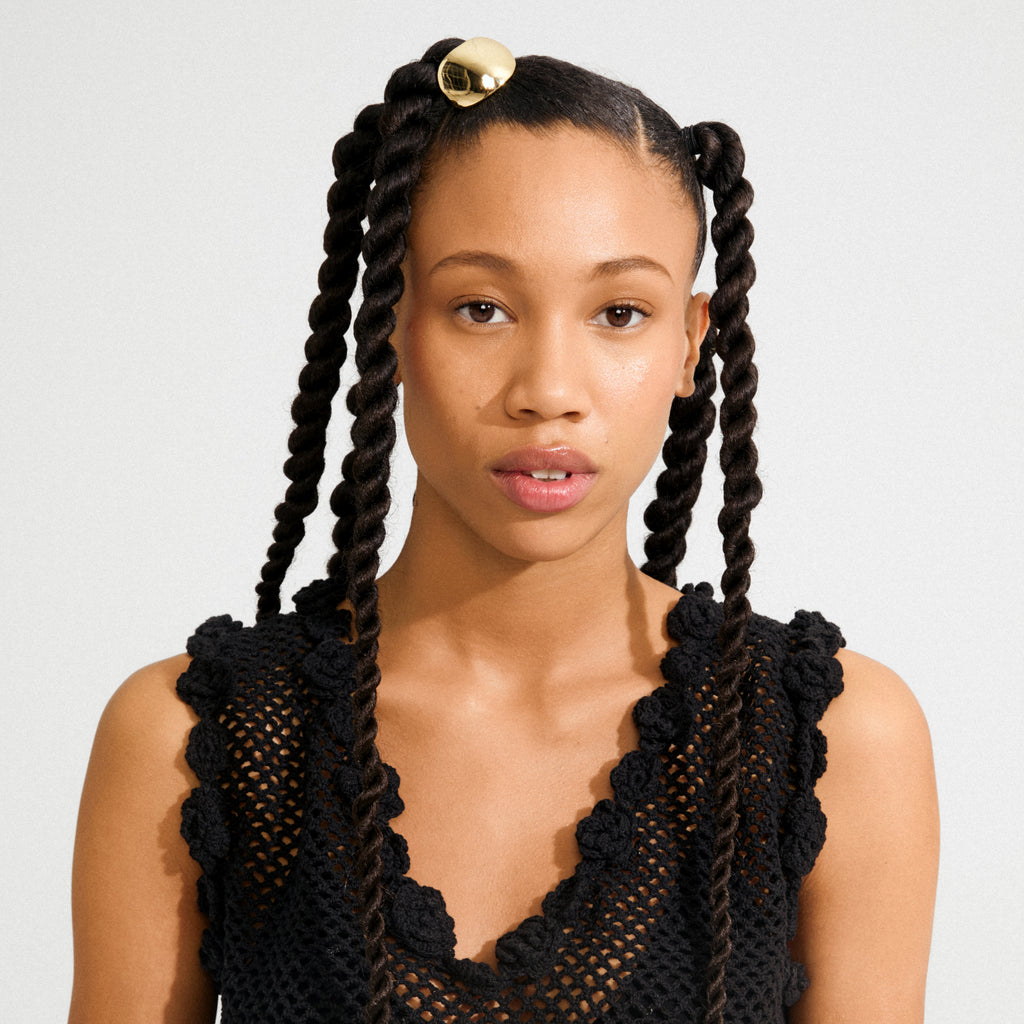 Young woman wearing the AMARIS hair accessory, a sleek gold-plated clip, adds elegance to her two-strand twist pigtails. Perfect for elevating everyday hairstyles.