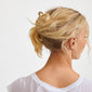 Gold-plated AMARIS hairpin securing a loose bun on a person with blonde hair, showcasing minimalist elegance and understated luxury.