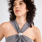 Young person wearing a grey rib-knit halter top with a silver metal accent, showcasing the AMARIS hair accessory, a sleek silver-plated elastic from Pilgrim.