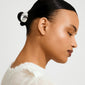Young woman with sleek, slicked-back bun featuring the AMARIS hair accessory, a shiny silver-plated clip from Pilgrim, adding a stylish touch to her look.