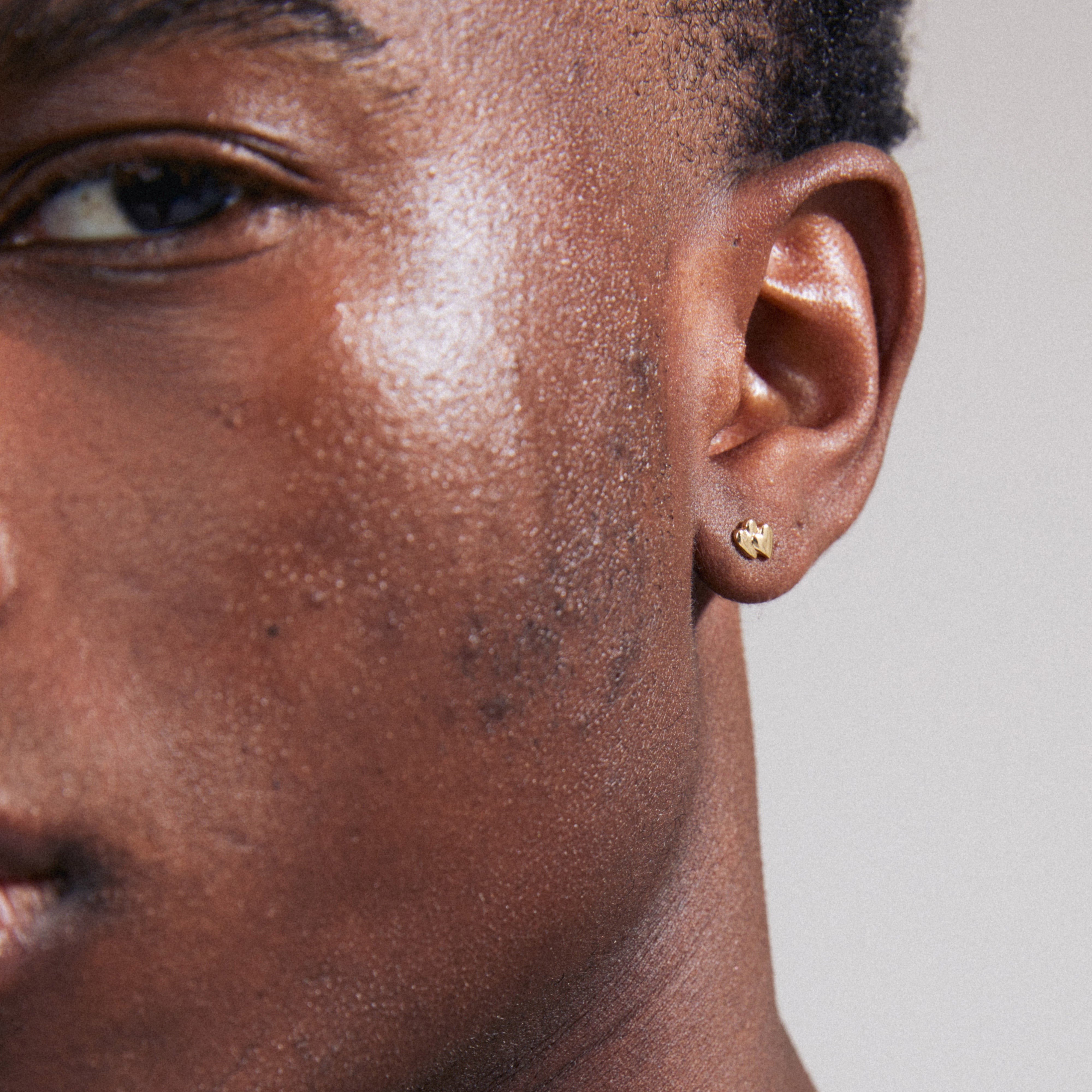 PRISKA single earring gold-plated, featuring two tiny heart shapes, perfect for personalizing your style. A sustainable choice crafted from 99% recycled material.