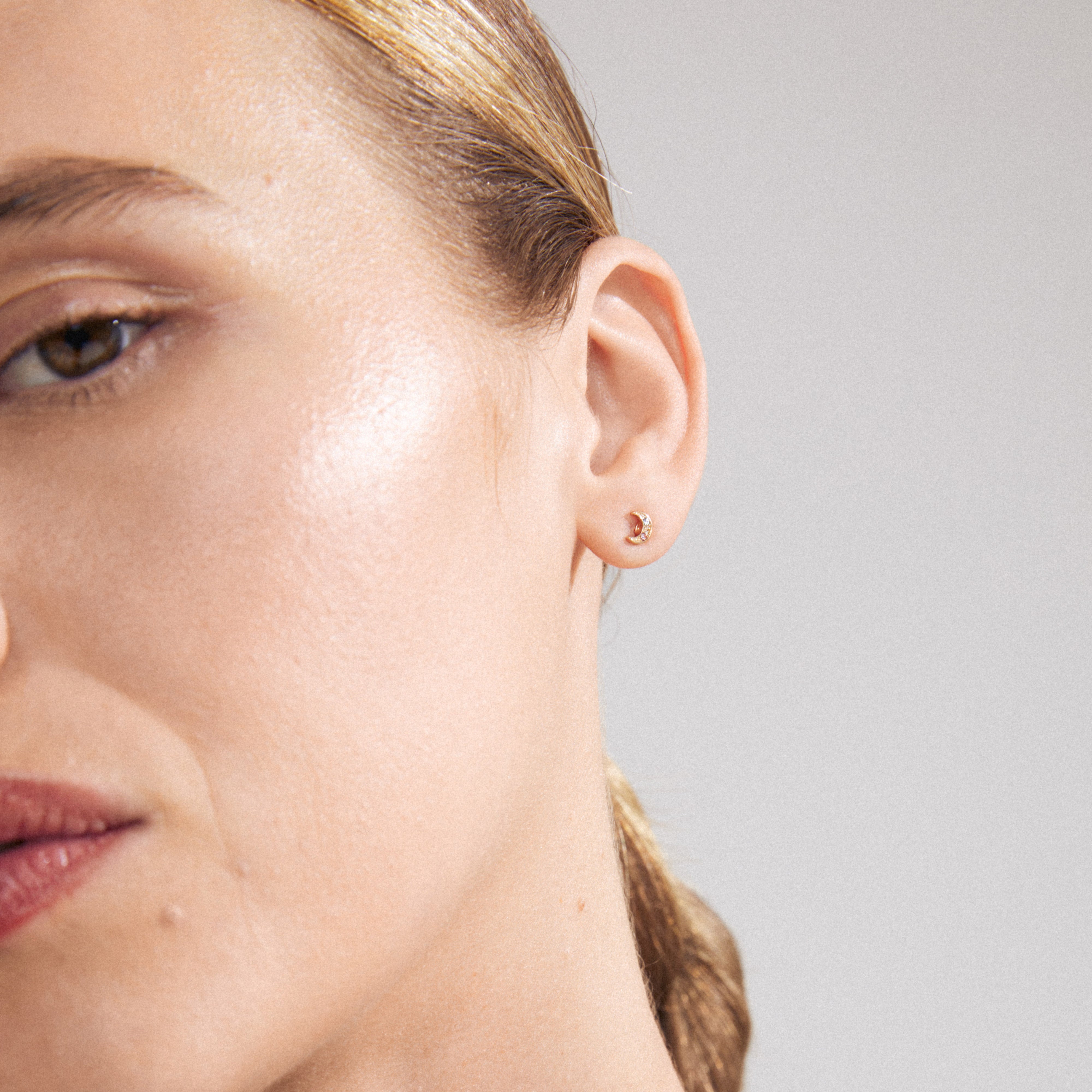 NATASSA single earring gold-plated, adorned with colorful Preciosa crystals, visible close-up on a woman's ear, showcasing its intricate design and sparkle.