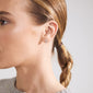 Close-up of a woman's ear wearing the PHYLLIS single earring, silver-plated and tree of life-shaped, showcasing its intricate design and personal touch.