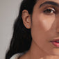 PRISKILLA single earring silver-plated, shaped like a snake, symbolizing renewal, crafted from 98% recycled materials, elegantly adorns a woman's ear.