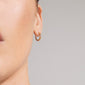 KYRA single earring gold-plated, textured hoop with an organic shape, showcased on an ear. Handcrafted, shiny finish, easy click clasp, made from recycled materials.