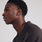 LAVRA single earring silver-plated, shown on a man's ear, featuring a shiny finish and easy-to-use click clasp. Timeless design, made from 99% recycled material.