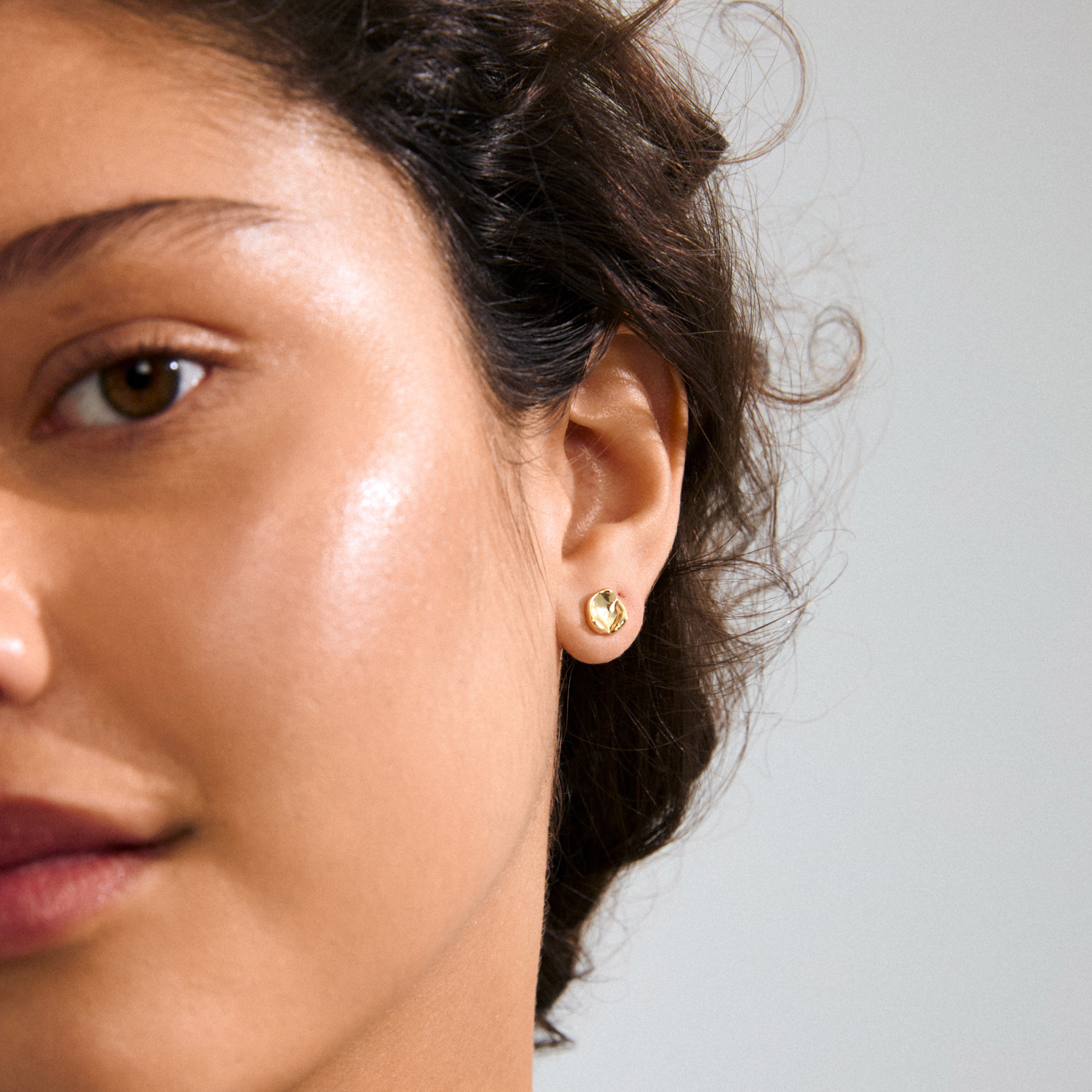 PORTER single earring gold-plated with organic disc shape, shiny finish, ideal for asymmetrical stacking. Crafted from 99% recycled materials, embodying Pilgrim's eco-friendly values.