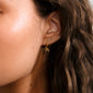 MURPHY single earring gold-plated: A charming huggie hoop featuring a tiny bow pendant, crafted from 99% recycled material with a convenient click clasp for easy wear.