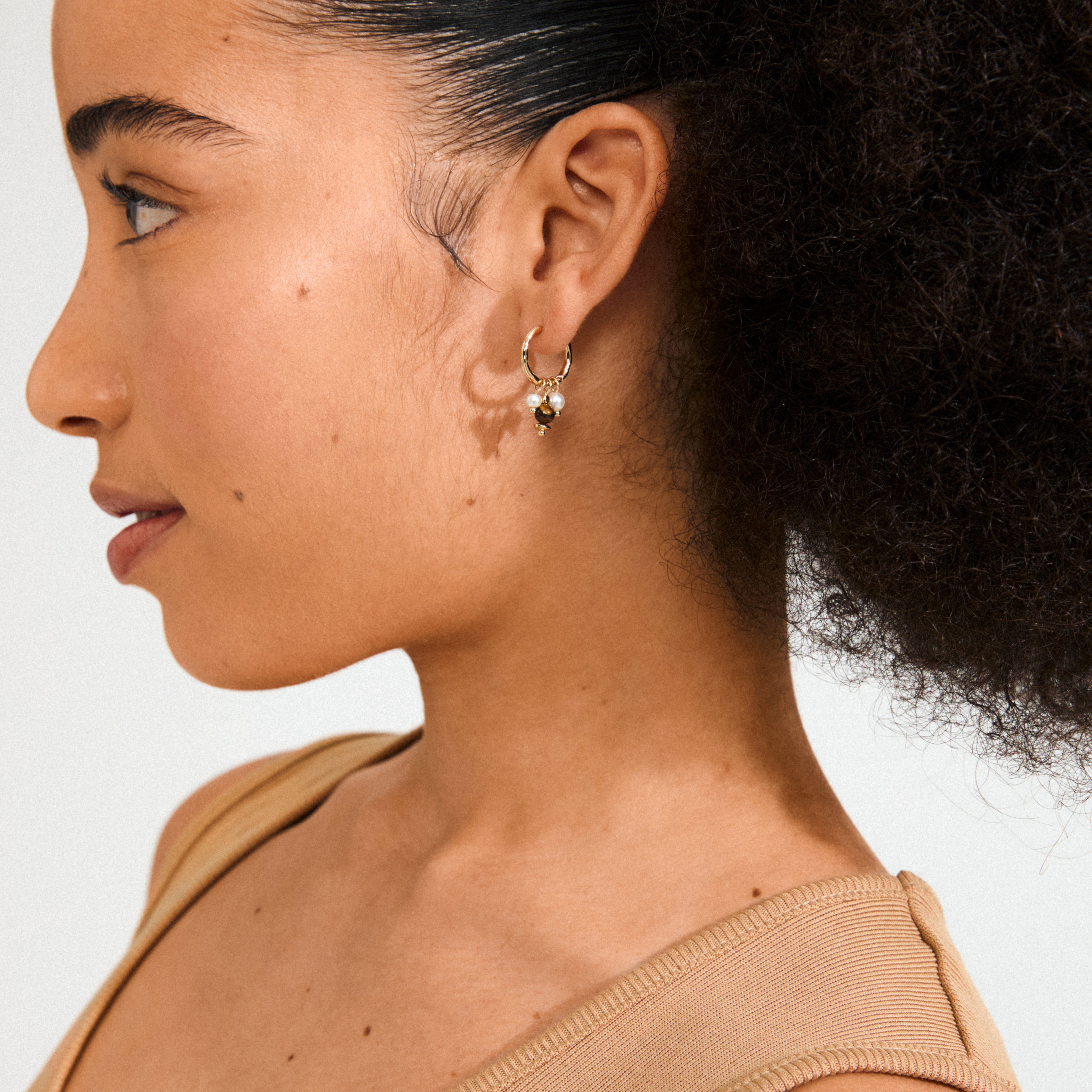 Gold-plated ROYAL single earring with Tiger Eye pendant and mother-of-pearl beads, featuring a click clasp for versatile styling.