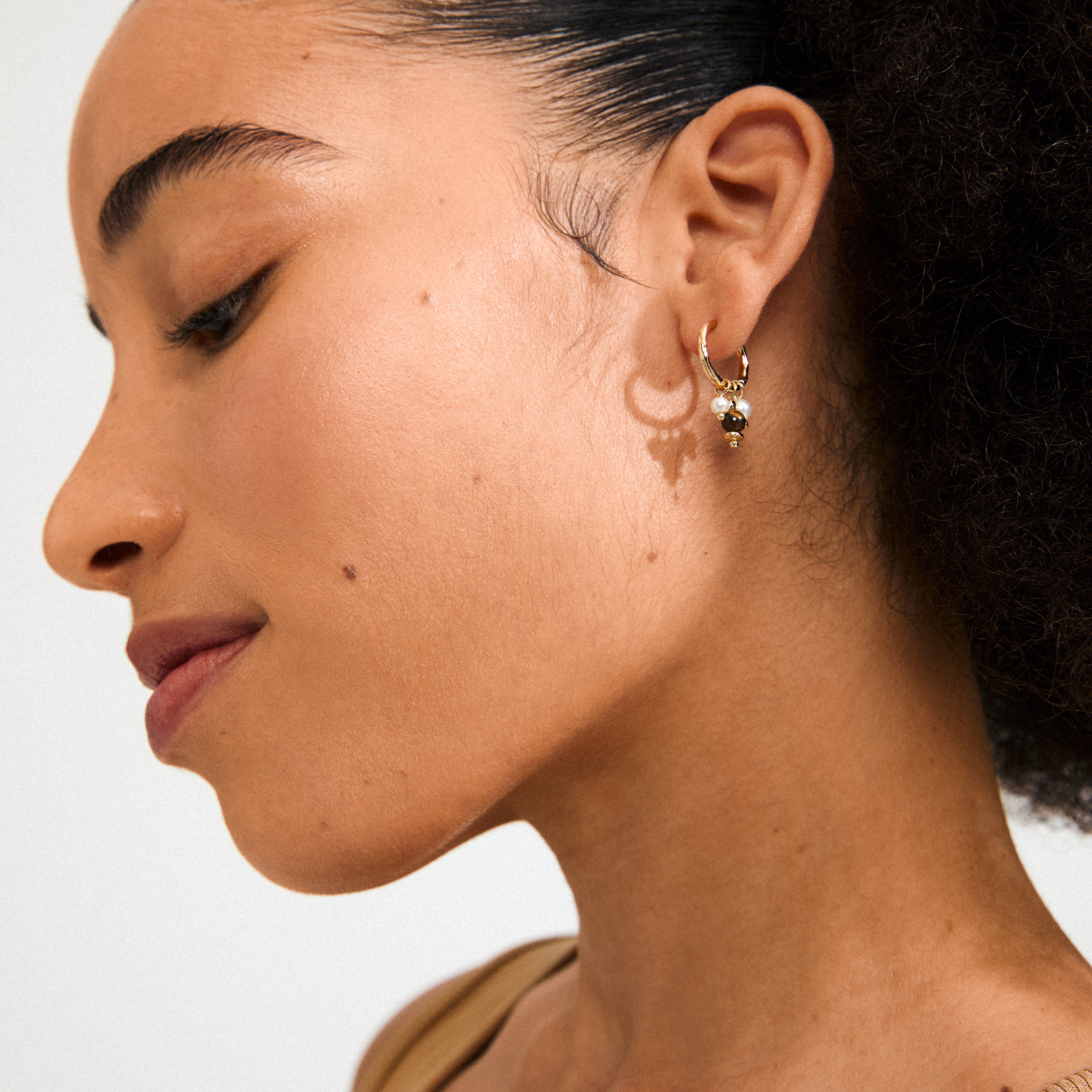 Gold-plated ROYAL single earring with Tiger Eye pendant and mother-of-pearl beads, featuring a click clasp for versatile styling.