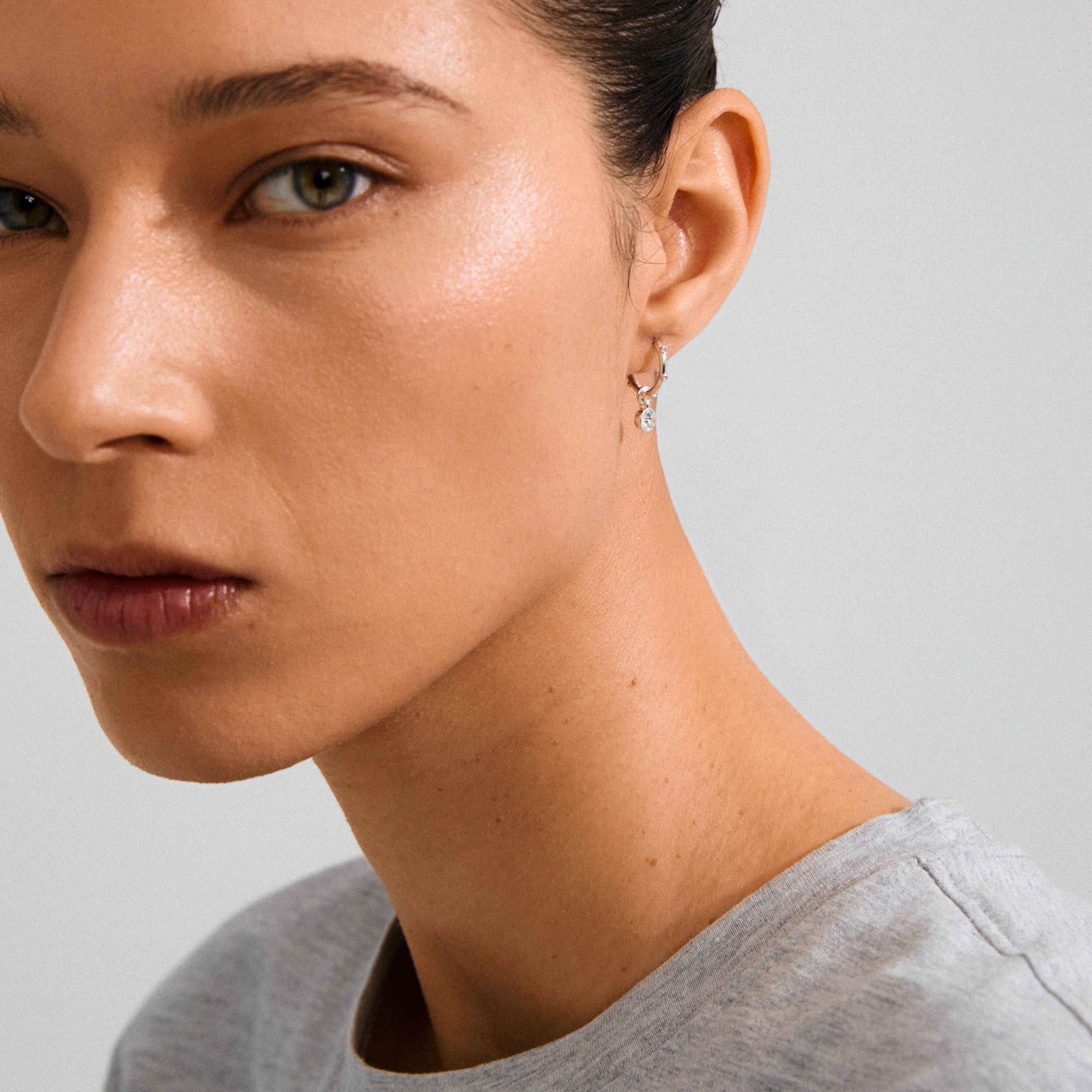 SUNNY single earring, silver-plated huggie hoop with sparkling Preciosa crystals and an elegant pendant, crafted from 98% recycled materials. Ideal for a chic, sustainable look.