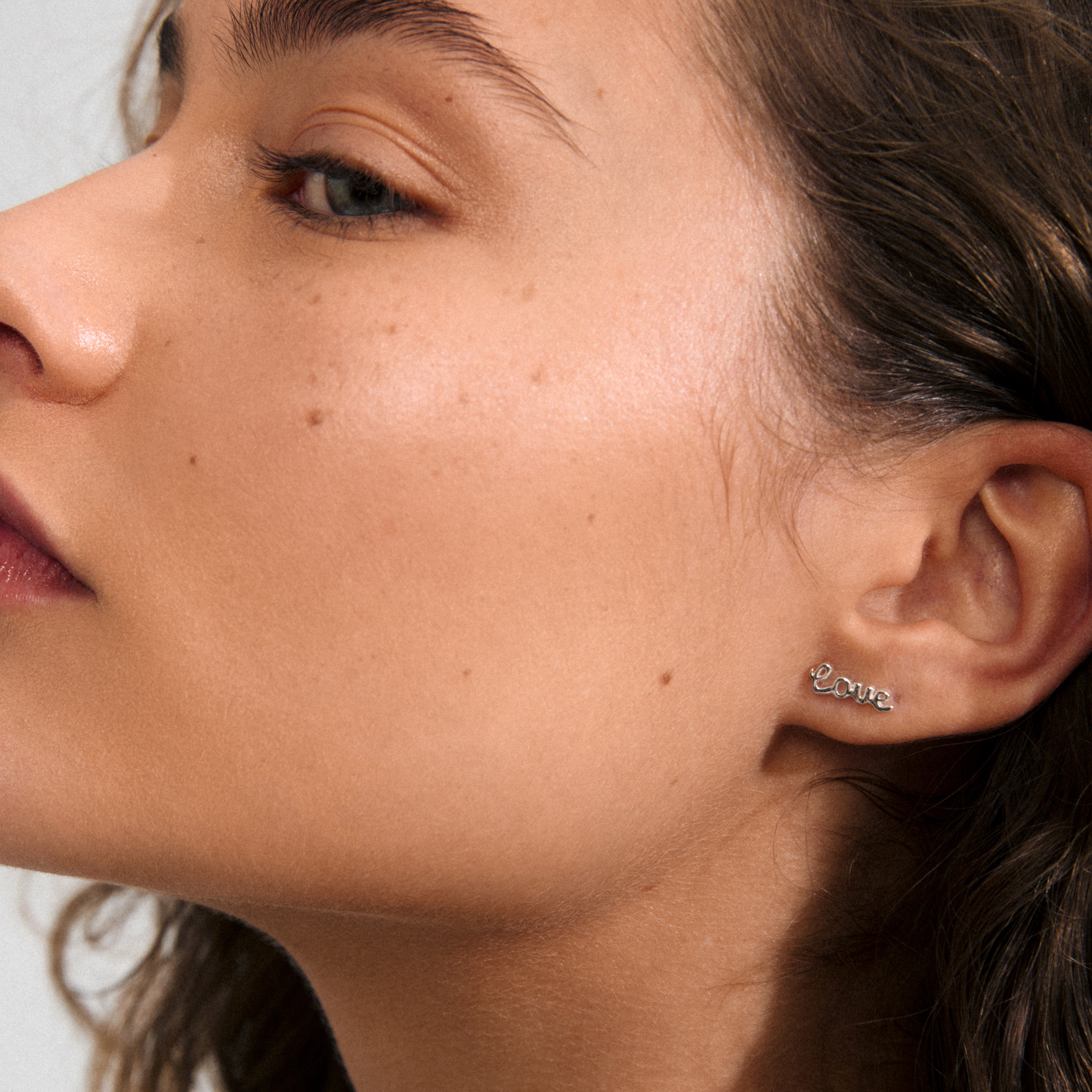 Silver-plated RIO single earring, featuring the word LOVE, crafted from 99% recycled material, conveying warmth and positivity. Ideal for solo or stacked wear.