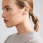 Close-up of a woman wearing the ADONIS single gold-plated earring shaped like a lightning bolt from Pilgrim, adorned with Preciosa crystals.