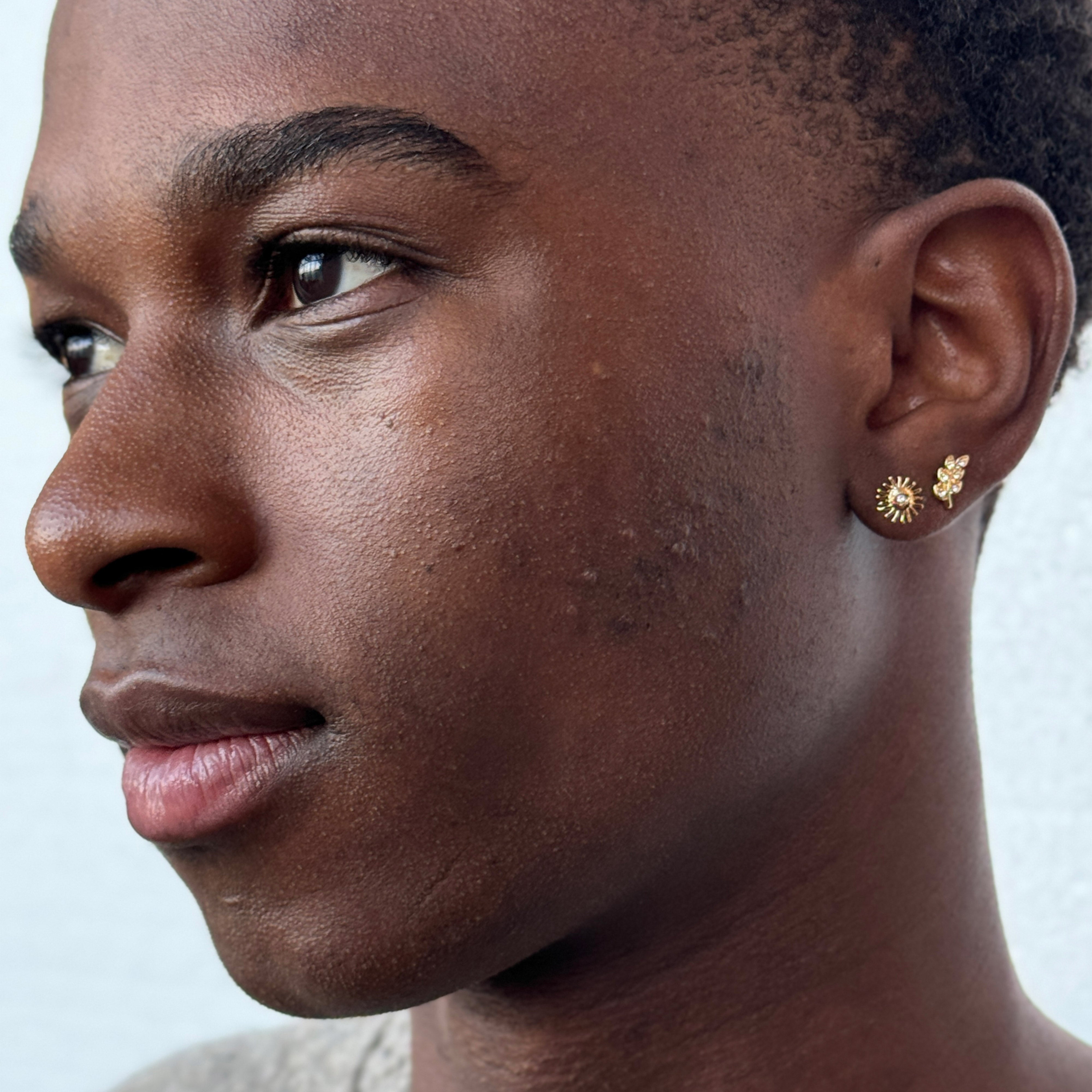 ARES single earring gold-plated, designed as a leaf with Preciosa crystals, worn by a man showcasing its elegance in an asymmetrical ear curation.