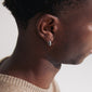 Close-up of a woman's ear adorned with the ZOE single silver-plated earring featuring Preciosa crystals and a click clasp.