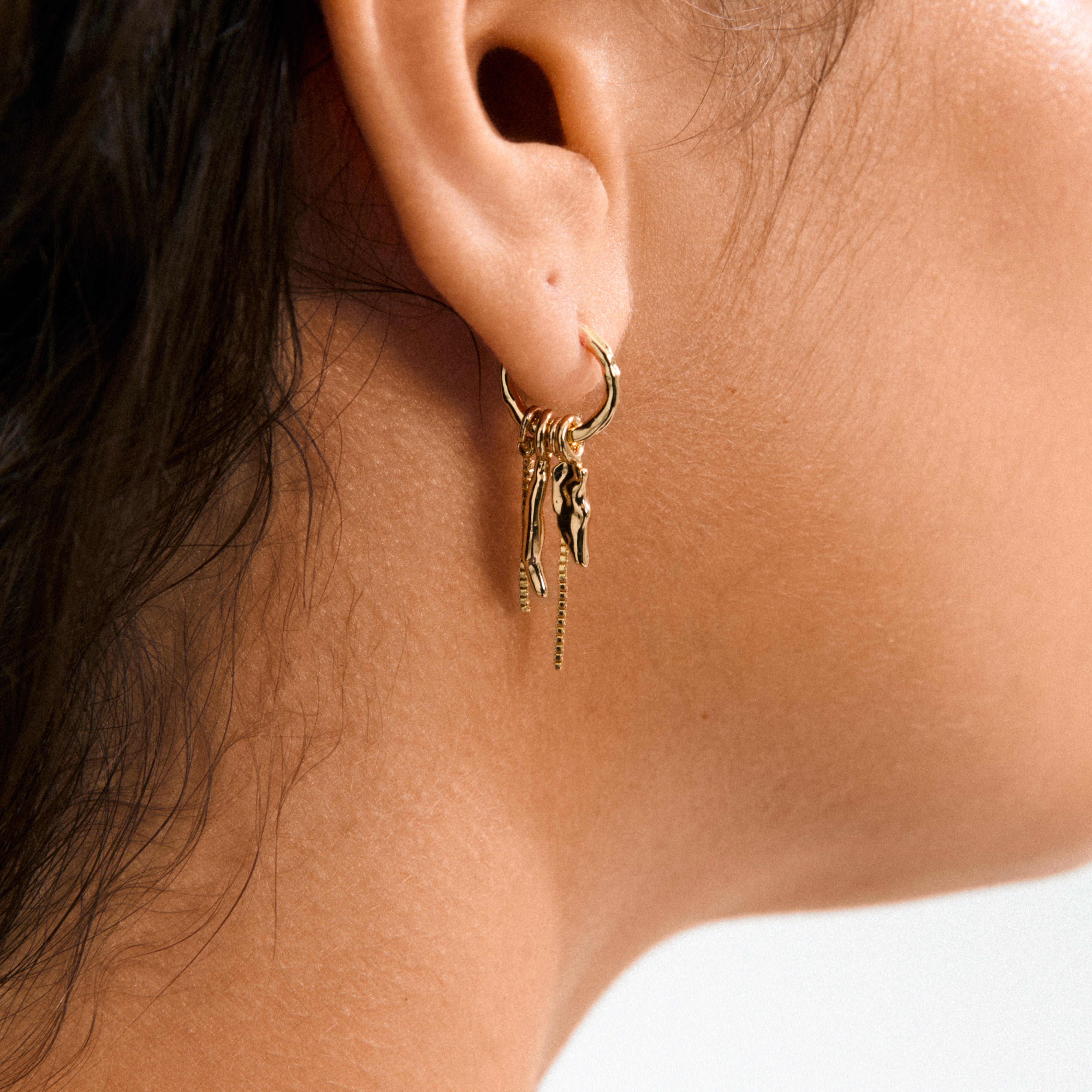 Gold-plated STERLING single earring with slender chains and organic pendants, showcasing a boho-chic, handcrafted style. Crafted from 99% recycled material.