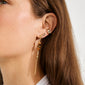 Close-up of an ear adorned with a gold-plated SKYLER ear cuff by Pilgrim, alongside other earrings, showcasing a stylish layered look.