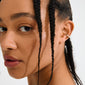 KEEGAN ear cuff gold-plated with sparkling Preciosa crystals, worn on a woman's ear with braids, showcasing elegant, effortless glam without needing a piercing.