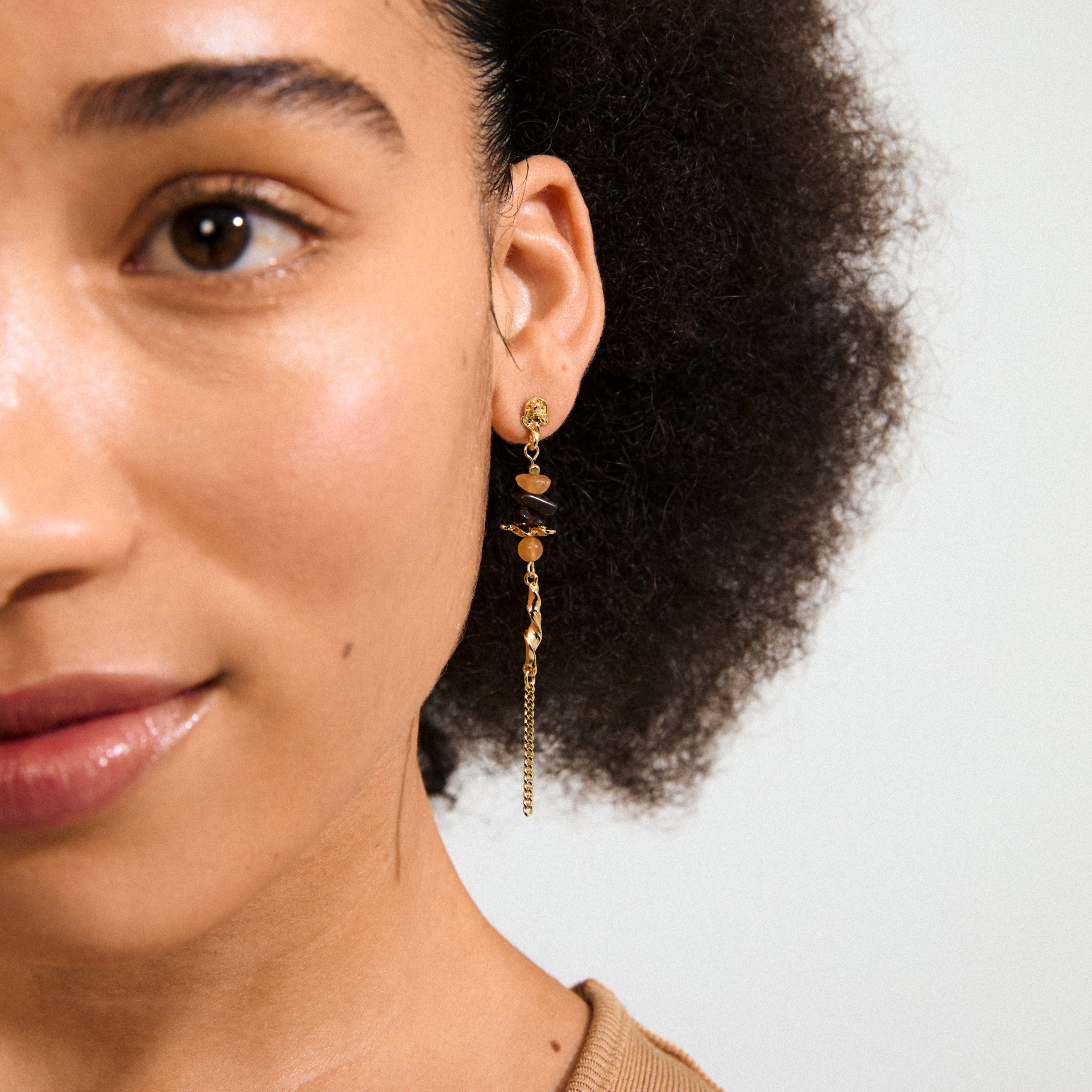 SUTTON single gold-plated earring featuring Aventurine and Tiger Eye stones, showcasing boho elegance with organic shapes for a unique, chic look.