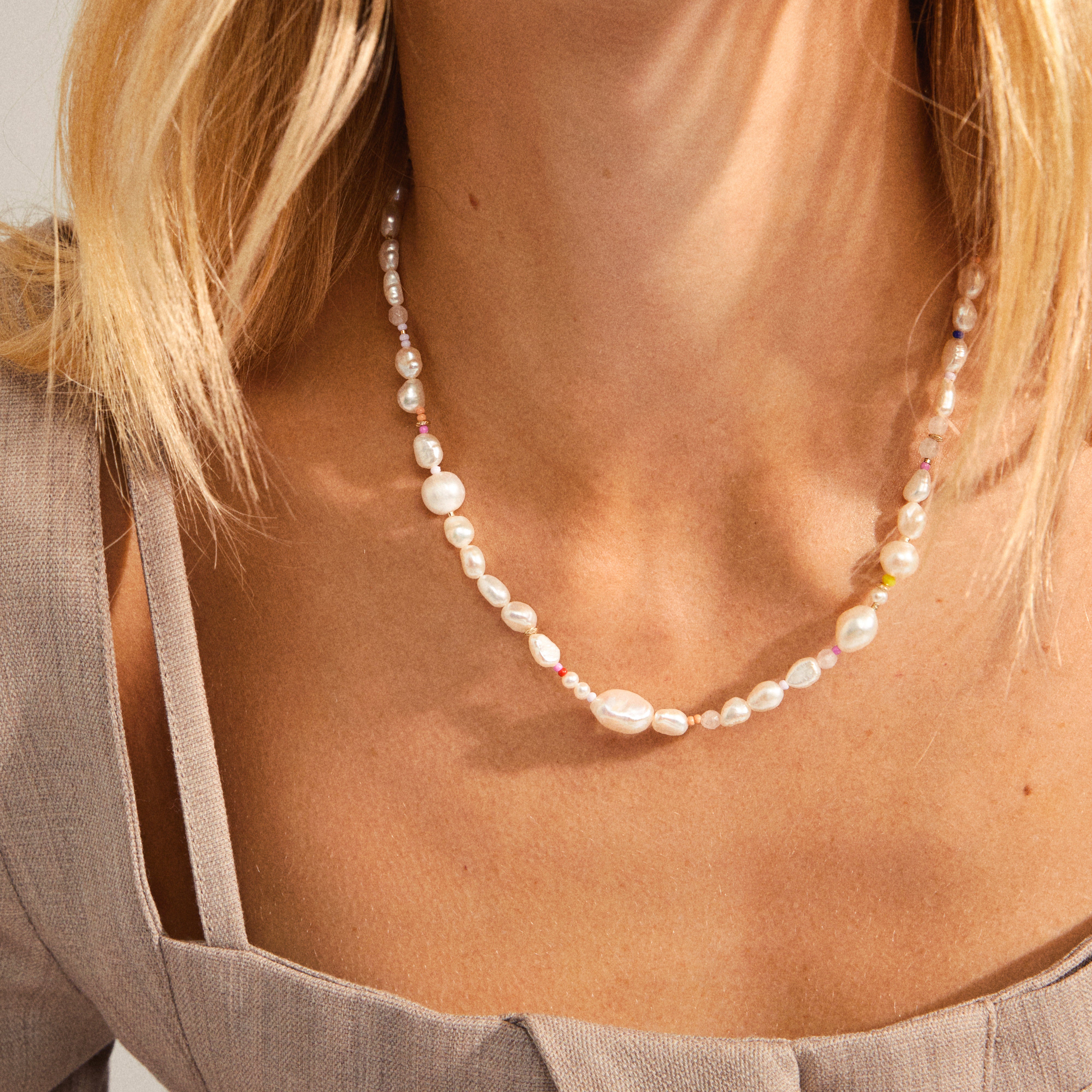RAMONA freshwater pearl necklace features irregular pearls with colorful spacer beads, elegantly draped around a woman's neck, showcasing Pilgrim's blend of classic and contemporary style.