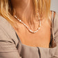 RAMONA freshwater pearl necklace gold-plated, featuring irregular freshwater pearls with colorful spacer beads, elegantly draped on a woman's décolletage, showcasing Pilgrim's Scandinavian craftsmanship.