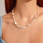 RAMONA freshwater pearl necklace silver-plated features irregular pearls and colored gemstones, elegantly accenting a light blue top on a model's neck and décolletage.
