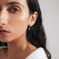 VASILKI single earring gold-plated, featuring a small organic-shaped pendant and mother-of-pearl-coloured bead, styled for an asymmetrical look.
