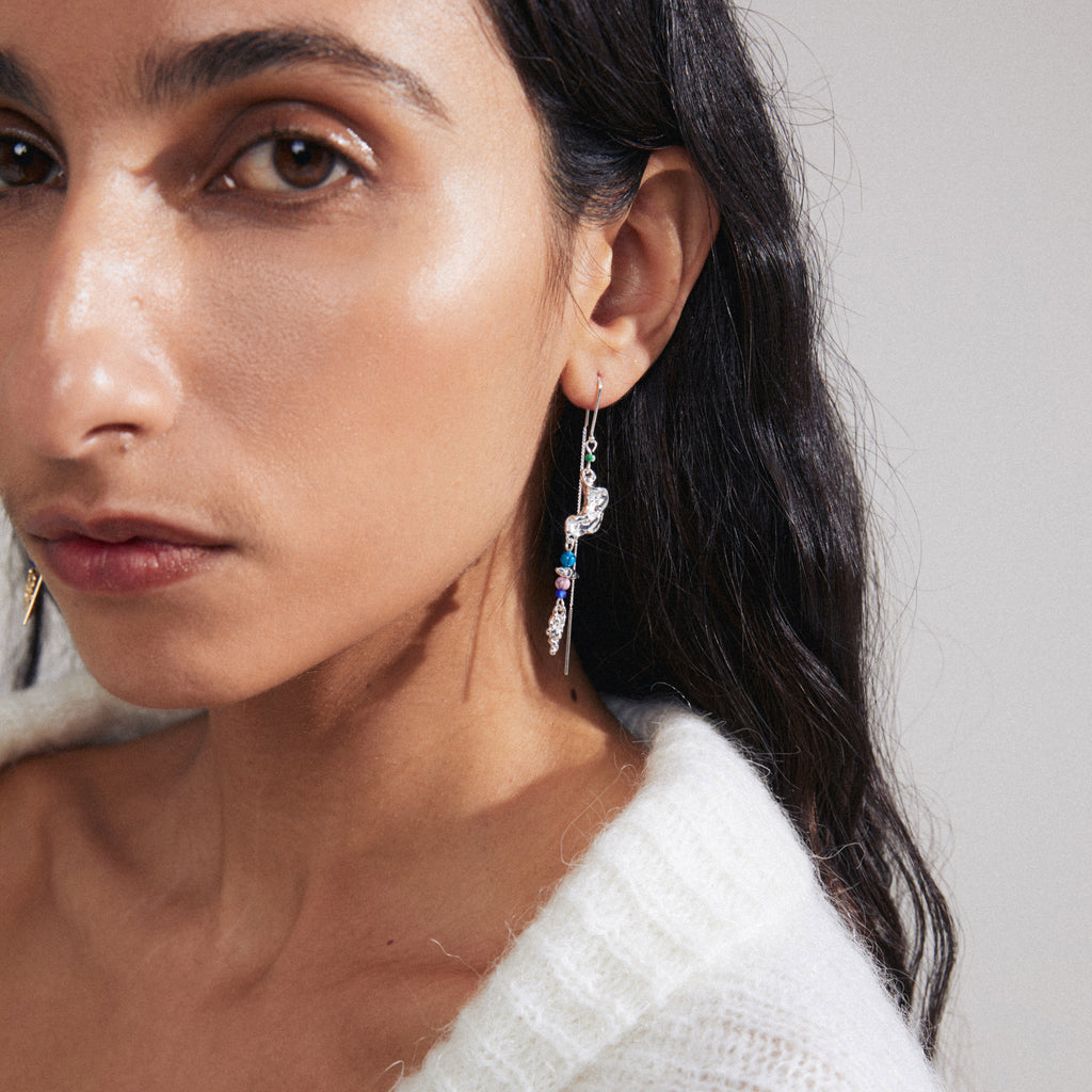 Woman wearing SELENE single earring, a silver-plated chain with colorful beads, showcasing an organic, handcrafted design.