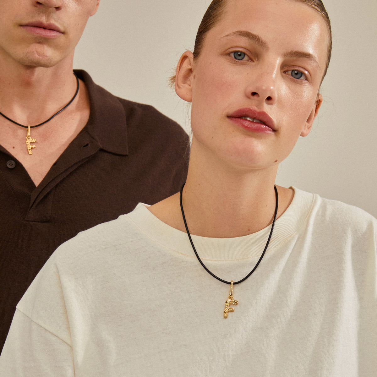 Gold-plated F charm pendant showcased on a necklace, highlighting Pilgrim's blend of style and sustainability with 99% recycled material.