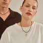 Gold-plated F charm pendant showcased on a necklace, highlighting Pilgrim's blend of style and sustainability with 99% recycled material.