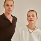A man and woman wearing Pilgrim's gold-plated CHARM pendant, showcasing personalized styling with rustic letter pendants.