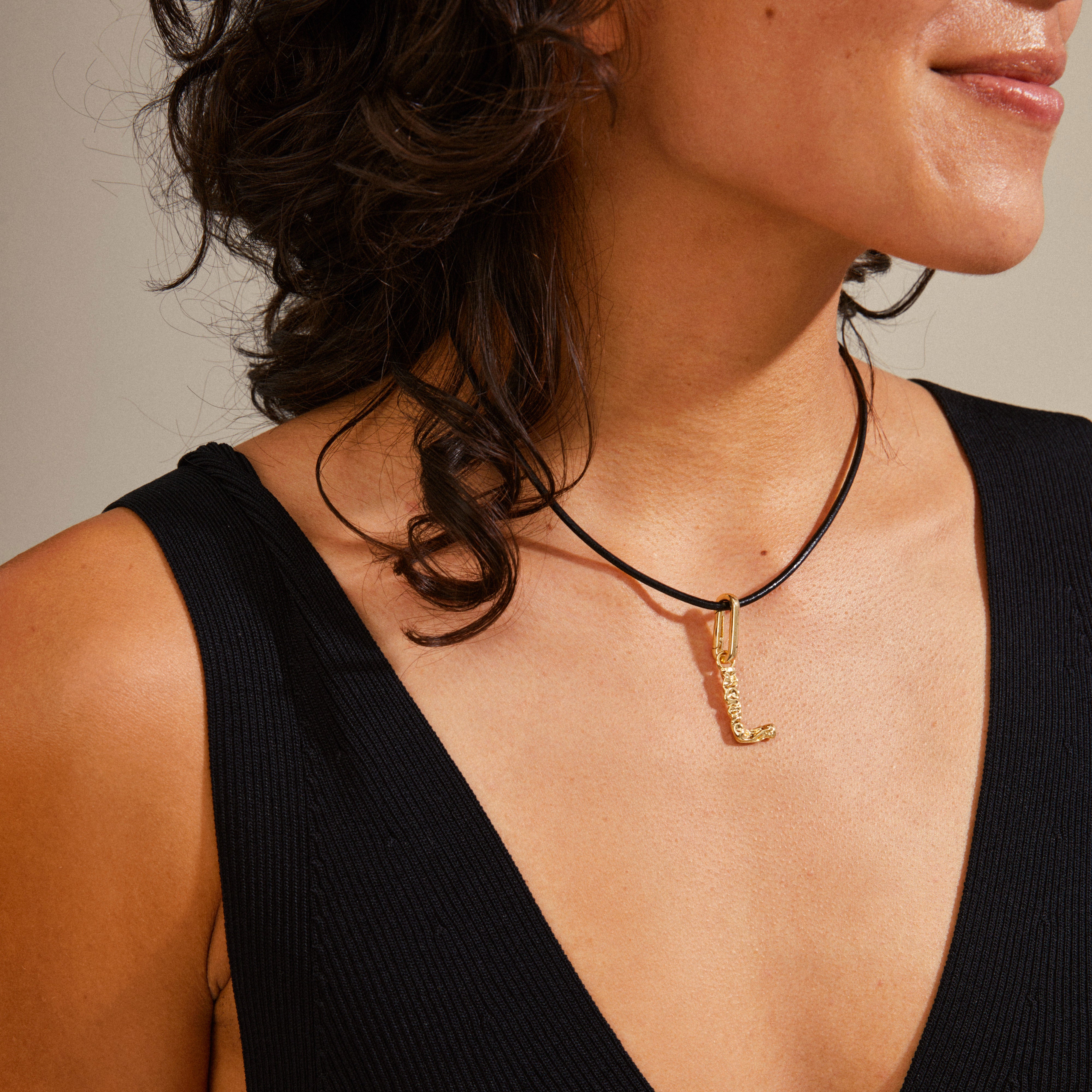 Gold-plated CHARM pendant L on a woman's neck, showcasing Pilgrim's personalized jewelry style with a focus on sustainable, recycled materials.