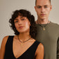 Gold-plated CHARM pendant N on a necklace, worn by a woman, showcasing Pilgrim's personalized, sustainable design for a unique, stylish statement.