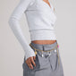 Woman wearing a grey outfit showcases the CHARM curb necklace gold-plated, a bold, adjustable gold-plated chain designed for adding charms and expressing urban style.