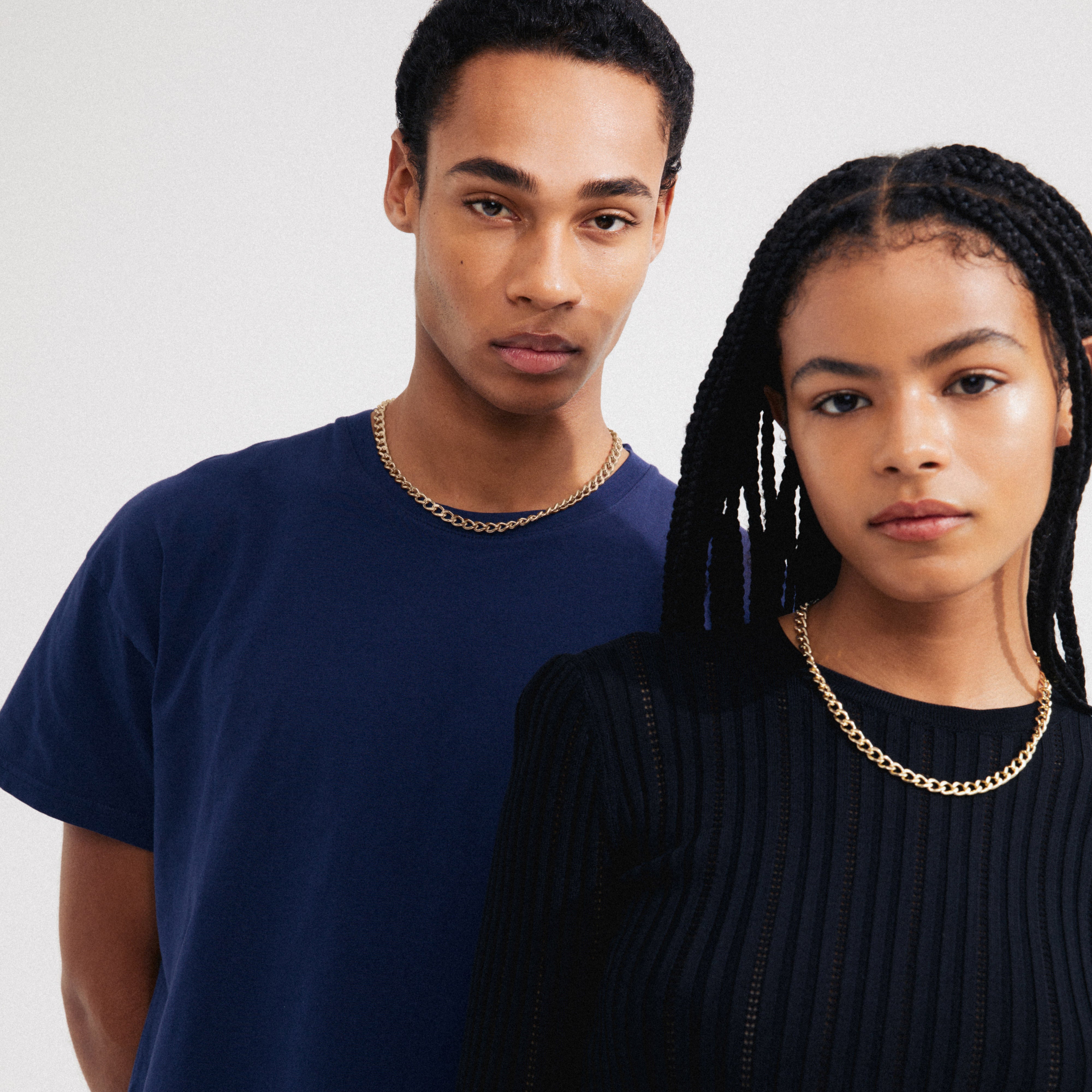 A man wearing the CHARM curb necklace gold-plated, showcasing its edgy, industrial design and adjustable length, perfect for adding personal charms.