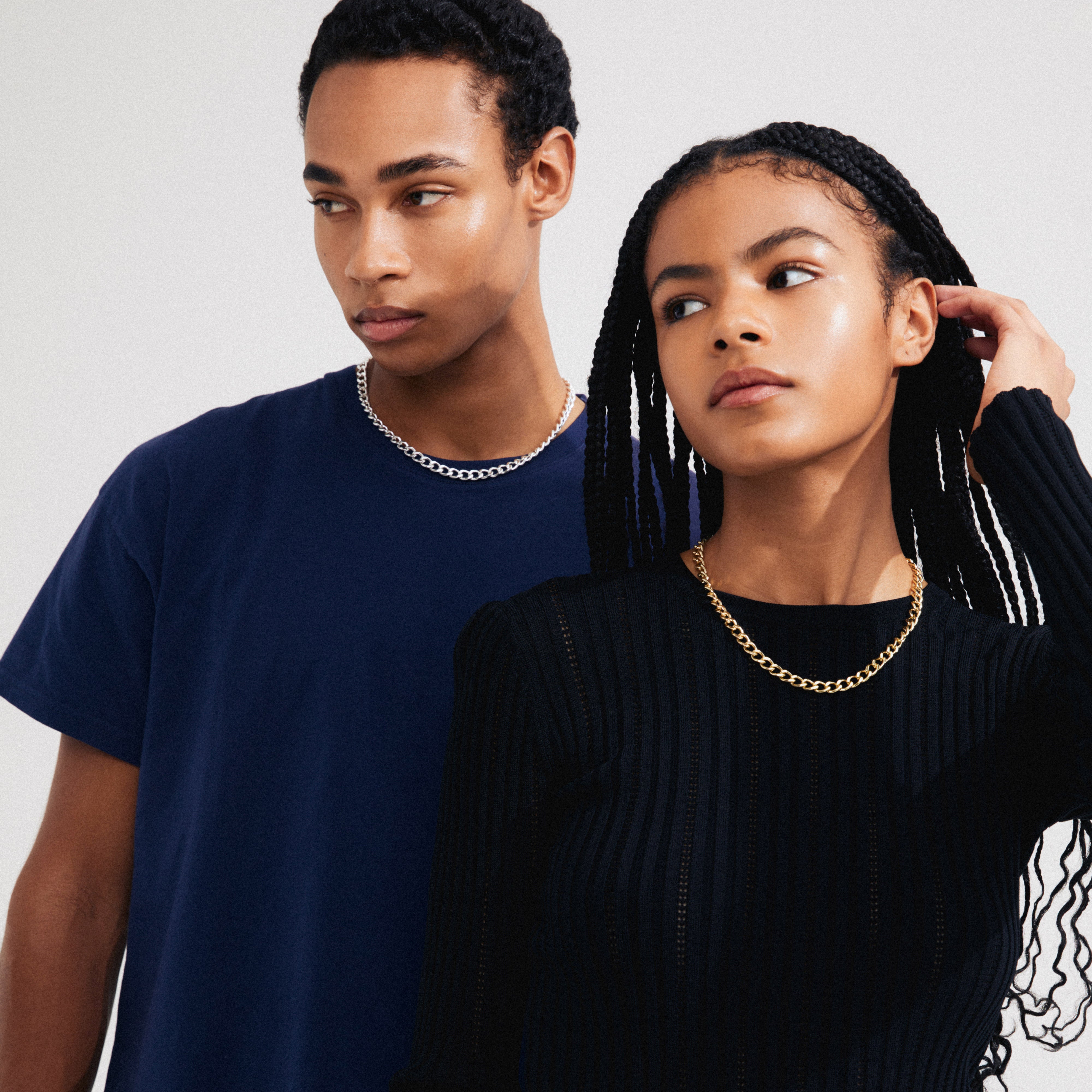 Man and woman showcasing the CHARM curb necklace gold-plated, emphasizing its elegant design and adjustable length for urban styling.