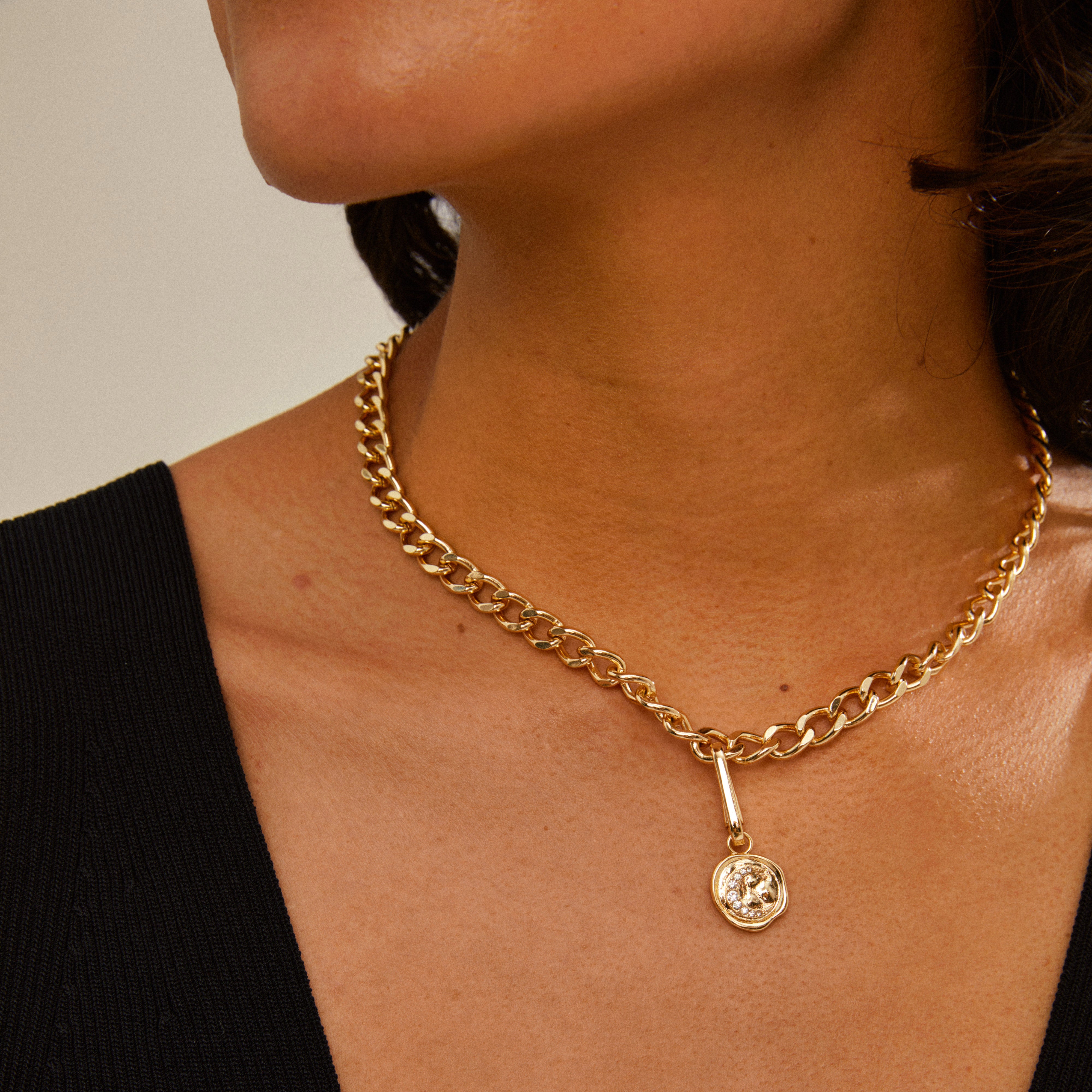 Woman wearing the CHARM moon pendant, gold-plated, on a chain, showcasing Pilgrim's blend of timeless and trendy Scandinavian jewellery design.