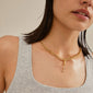 Woman wearing Pilgrim's CHARM Love pendant, gold-plated, showcasing a personalized statement piece on a necklace, reflecting Scandinavian craftsmanship and contemporary style.