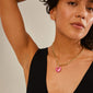 Woman wearing Pilgrim's CHARM heart pendant, pink/gold-plated, showcasing a stylish and personalized fashion accessory with a close-up of the necklace.