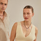 Man and woman showcasing Pilgrim's CHARM pendant K, silver-plated, emphasizing personal style with a unique, rustic design perfect for trendy, sustainable accessorizing.