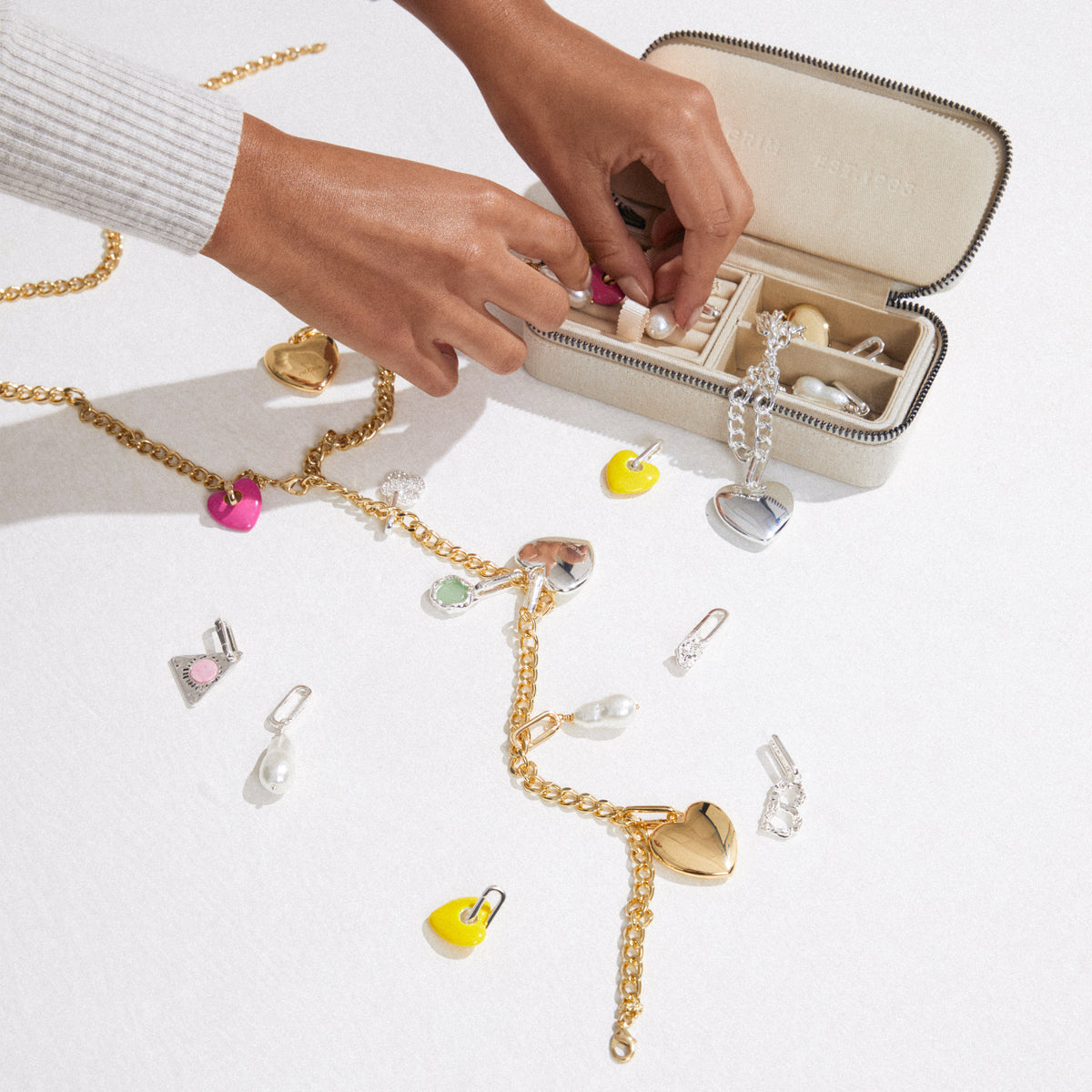 Hand holding the CHARM curb chain bracelet, silver-plated, showcasing its bold design perfect for stacking with charms, emphasizing urban style and sustainability.