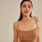 Woman wearing Pilgrim's CHARM coin pendant, silver-plated, showcasing a rustic look and personal style. Perfect for a unique, sustainable fashion statement.