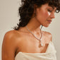 Woman wearing a necklace with Pilgrim's CHARM pearl pendant, silver-plated, delicately styled to enhance personal expression and contemporary elegance.