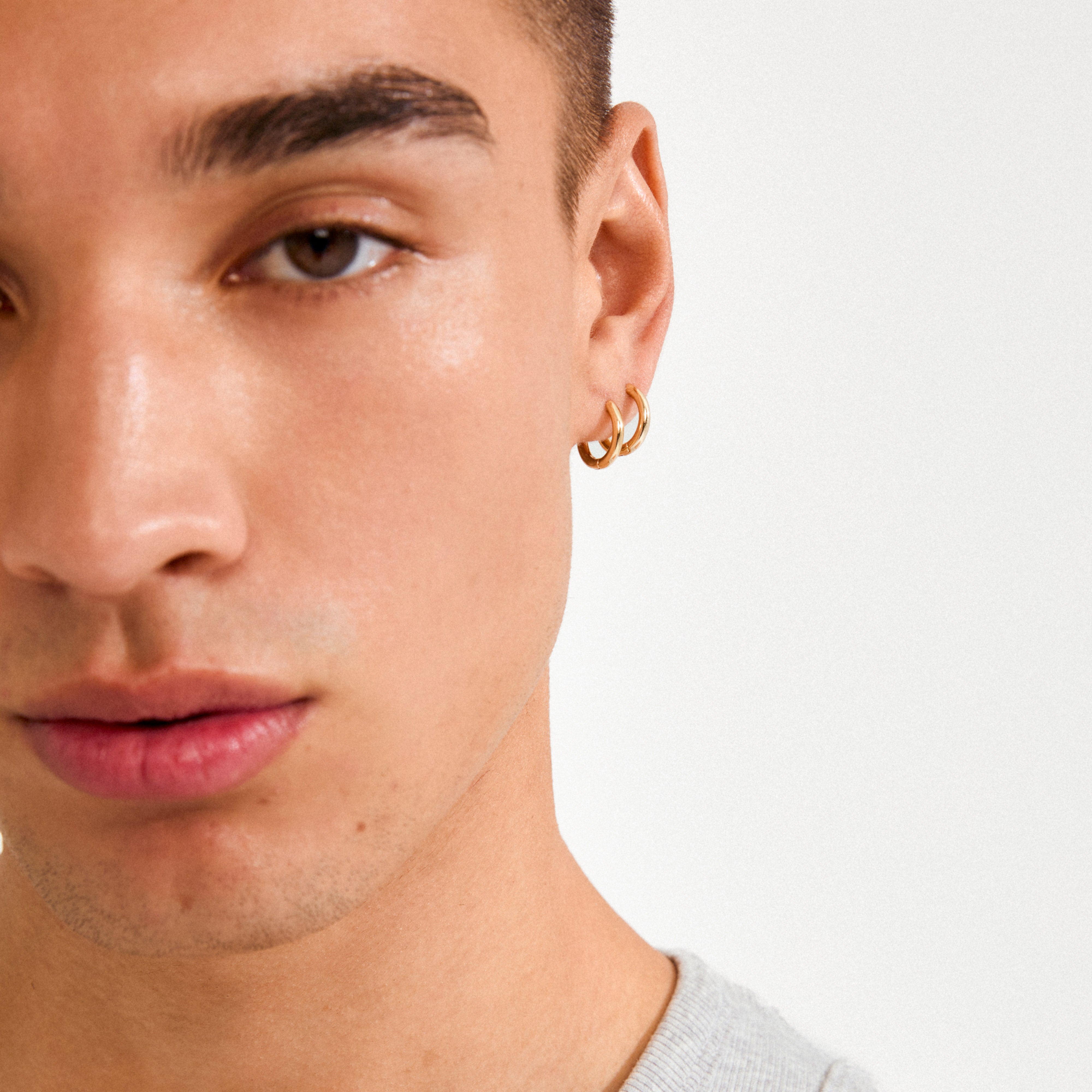 Close-up of a young person wearing CHARM small gold-plated hoop earrings, designed for personalized charm additions, ideal for creating a signature look.