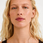 Young woman wearing CHARM small gold-plated hoop earrings, designed for adding charms, highlighting Pilgrim's blend of timeless Scandinavian craftsmanship and trendy, personal style options.