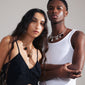 CHARM necklace gold-plated on a woman’s neck, featuring an adjustable 50 cm cable chain with a decorative T-bar clasp, embodying edgy, industrial style.