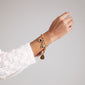 Person wearing a CHARM bracelet gold-plated with a delicate cable chain design, perfect for adding charms and stacking, highlighting edgy, urban style.