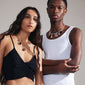 A man and woman showcase the CHARM black agate pendant, gold-plated, highlighting its versatility and stylish appeal as a personal fashion statement.