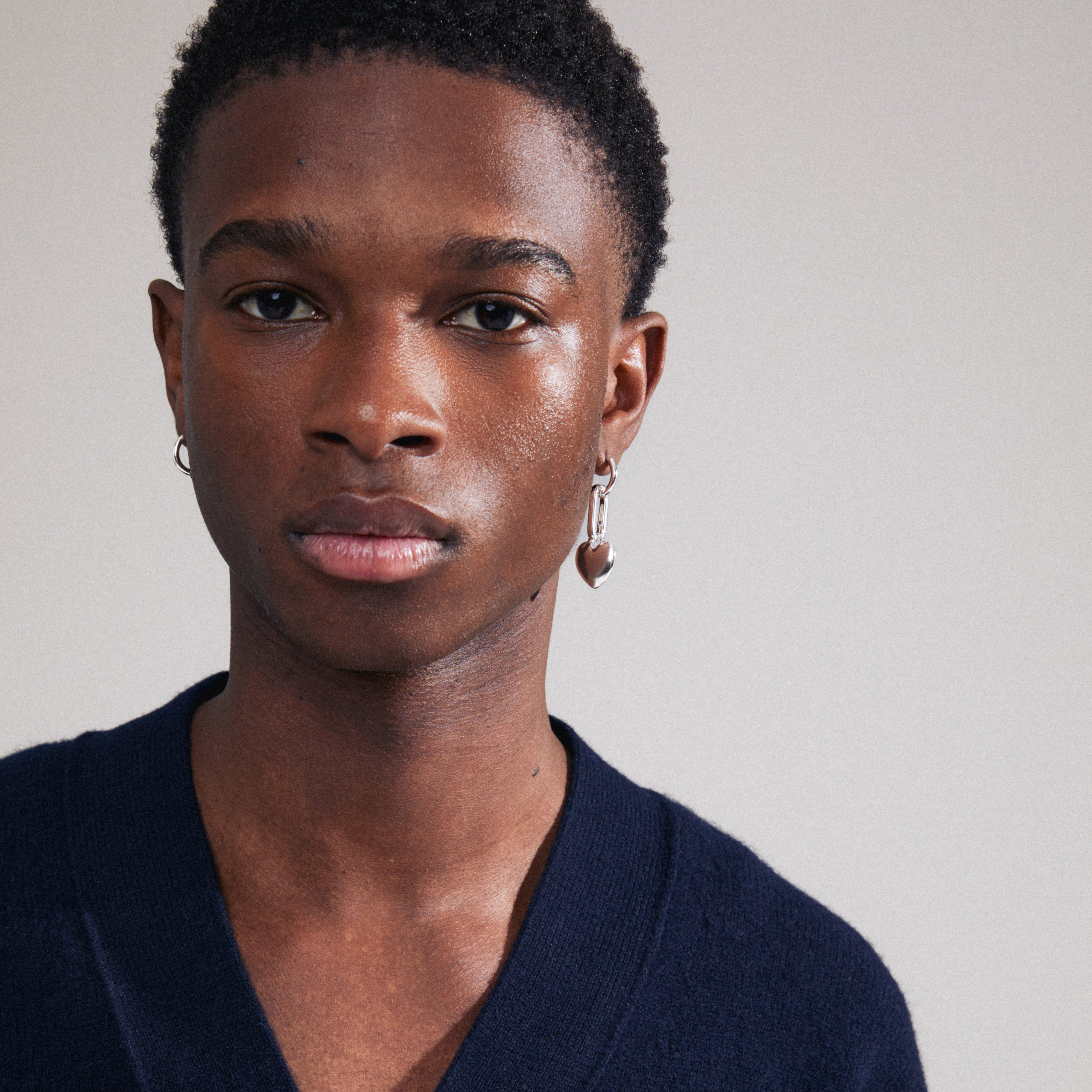 Close-up of a man wearing CHARM small silver-plated hoop earrings, designed for adding personalized charms, blending timeless style with modern flair.