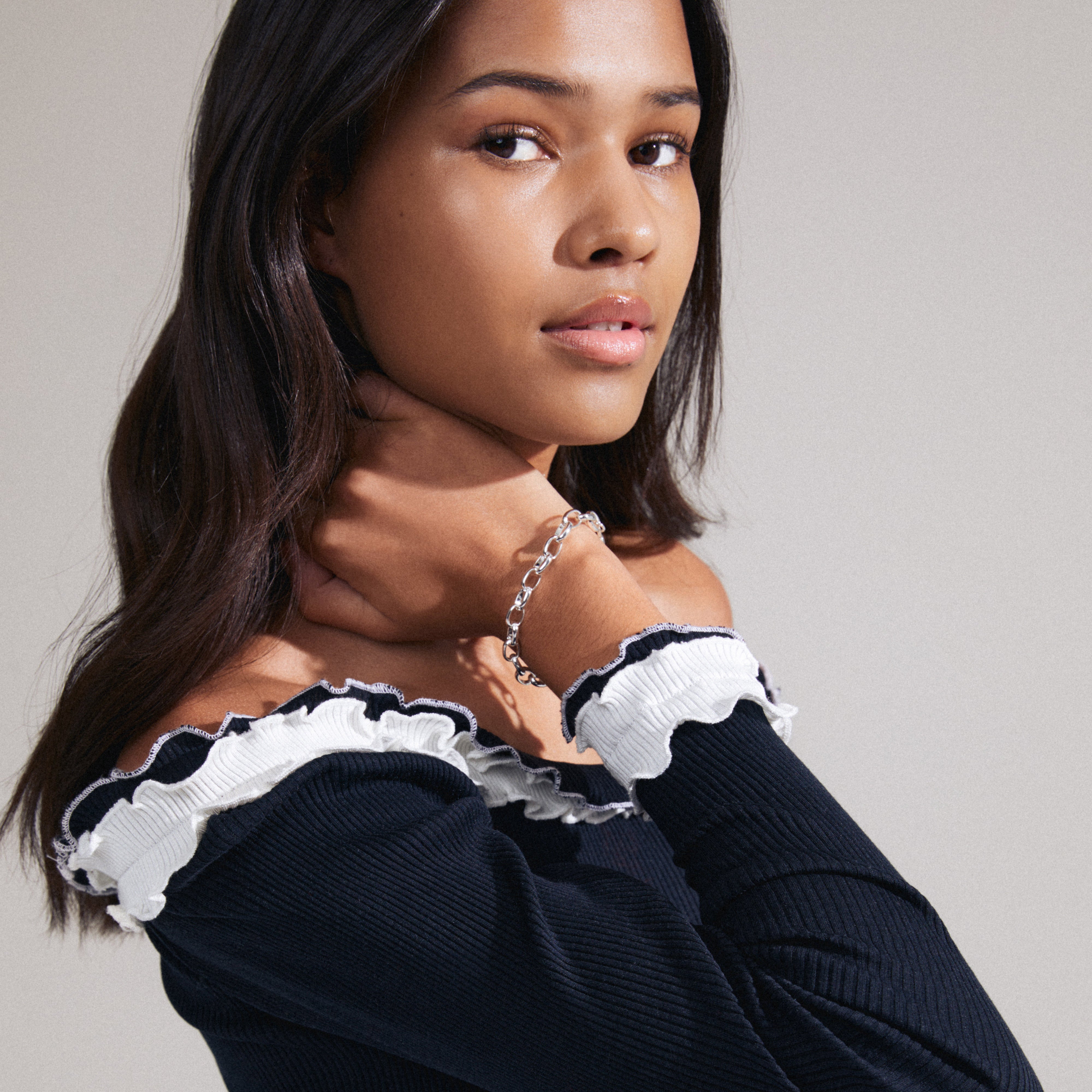 Woman wearing the CHARM bracelet, silver-plated cable chain, showcasing its edgy, industrial design ideal for stacking with other bracelets.